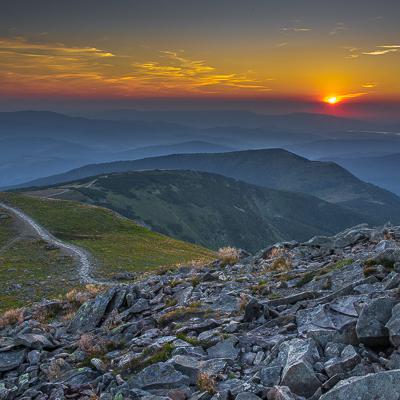 Papier peint  Le soleil couchant derrière les montagnes