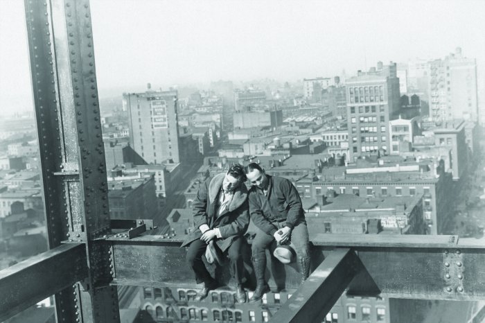 Papier peint  Hommes sur une structure métallique sur fond de ville