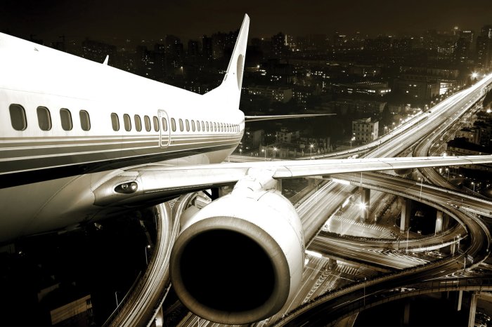 Papier peint  Avion sur fond de paysage urbain la nuit