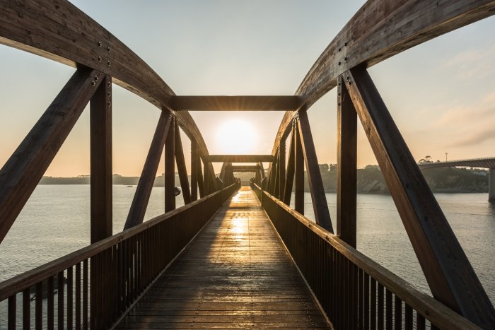 Papier peint  Pont en bois au-dessus de la rivière sous les rayons du soleil