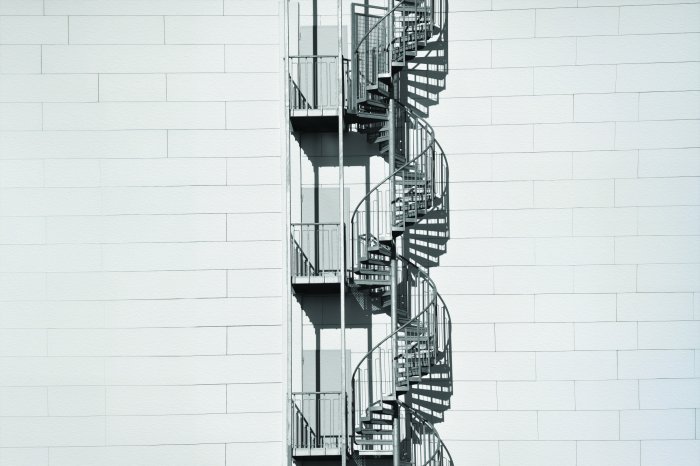 Papier peint  Escalier en colimaçon sur un mur en briques blanches