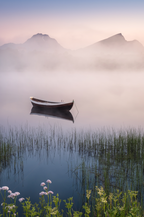 Tableau  Un bateau abandonné sur un lac, avec des montagnes en arrière-plan, dans le brouillard