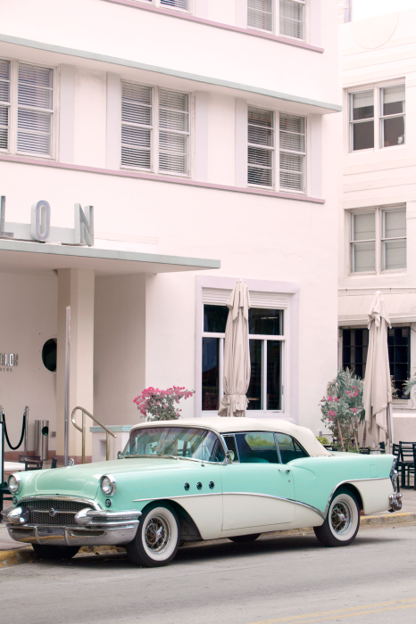 Tableau  Une voiture classique bleue devant un hôtel rose