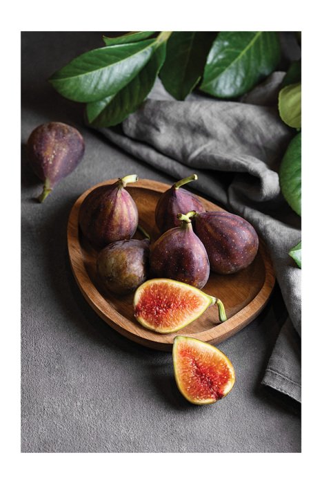 Poster  Une composition naturelle avec des figues et des feuilles sur le plan de travail de la cuisine