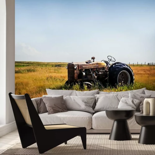 Papier peint  Un vieux tracteur rouillé rouge vintage assis dans un pâturage clôturé dans un paysage de campagne agricole d'été rural