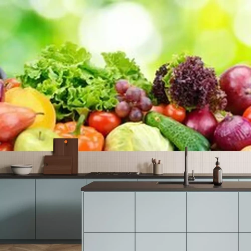 Sticker  Panorama de fruits et légumes frais sur fond flou de feuilles vertes.