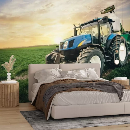 Papier peint  Un tracteur avec un sac d'engrais se déplace le long du champ au printemps