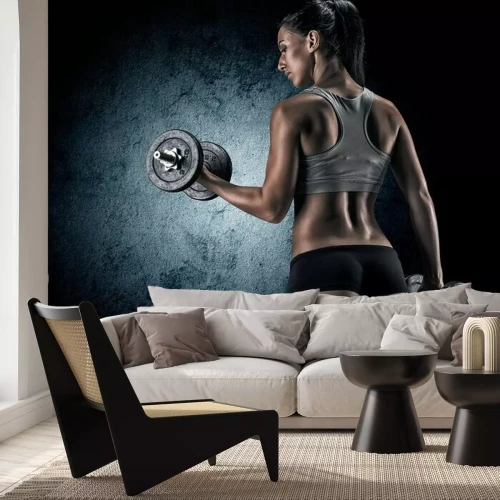 Papier peint  Femme musclée en studio sur fond sombre