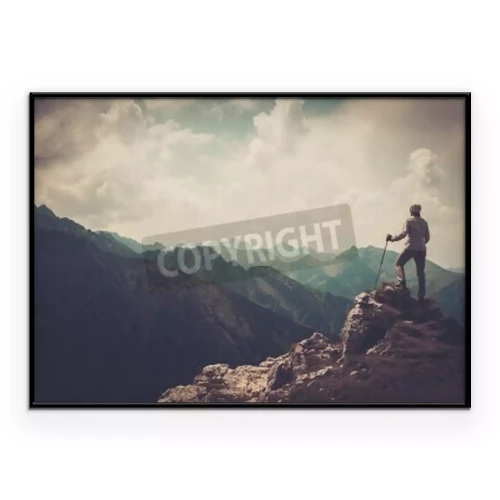 Poster  Un touriste debout au sommet d'une montagne