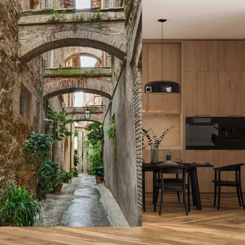 Papier peint  Une rue italienne pavée, avec des arcades et des fleurs en pot.